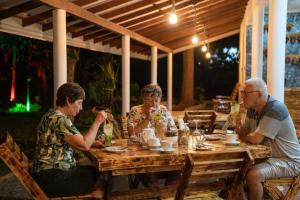 a group of people sitting at a wooden table at Heaven Habarana in Habarana