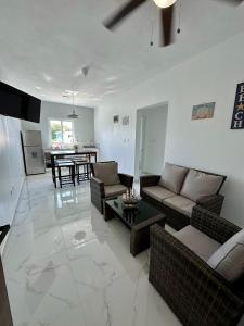a living room with couches and a table and a kitchen at Sunrise ApartaHotel in El Manguito