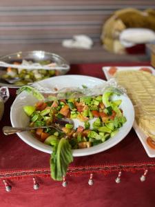 einen Salat auf einem weißen Teller auf einem Tisch in der Unterkunft Magic mountains rum in Disah