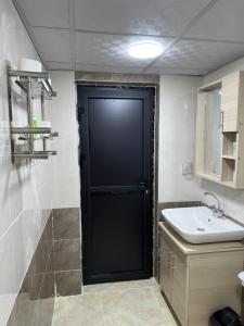 eine schwarze Tür in einem Badezimmer mit Waschbecken in der Unterkunft Magic mountains rum in Disah + 77 Fotos