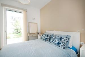 a bedroom with a bed with blue pillows and a window at Apostolaki A. Apartment in Rethymno Town