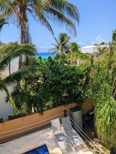 Modern Beach Villa Pool Ocean Views Terrace BBQ Villa Vista Real في بلايا ديل كارمن: منظر للمنتجع مع كرسيين والمحيط