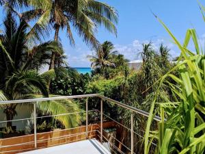 Modern Beach Villa Pool Ocean Views Terrace BBQ Villa Vista Real في بلايا ديل كارمن: بلكونة مطلة على المحيط والنخيل