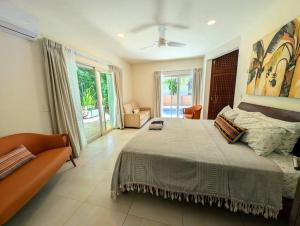 Modern Beach Villa Pool Ocean Views Terrace BBQ Villa Vista Real في بلايا ديل كارمن: غرفة نوم بها سرير كبير وأريكة