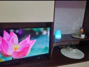 a television with a pink flower on the screen at Iris Opera Center in Ruse