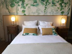 a bedroom with a white bed with two lamps at Les visages des Tournelles in Reims