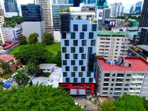 a tall white building with a red roof in a city at Hotel Mio Panamá in Panama City