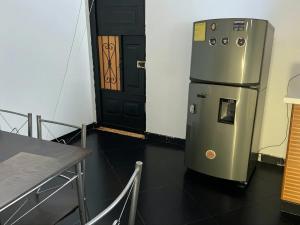 een koelkast in een kamer met een tafel en een deur bij Aparta Suite Torre De Prado 301 in Medellín