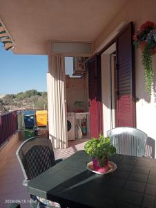 een groene tafel met stoelen en een plant op een balkon bij Marina di Ragusa House Relax in Marina di Ragusa