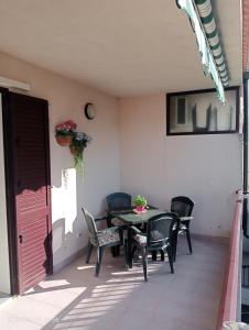 een patio met een tafel en stoelen bij Marina di Ragusa House Relax in Marina di Ragusa +15 foto's