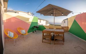 a patio with a table and chairs and an umbrella at CASA TUCAN - BEACH JUNGLE PARADISE in Ensenada