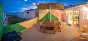 a patio with a table and chairs and an umbrella at CASA TUCAN - BEACH JUNGLE PARADISE in Ensenada