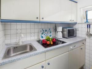 Una encimera de cocina con fregadero y microondas. en Apartment No 3 Modern retreat, en Norderney