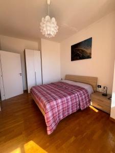 a bedroom with a bed with a plaid blanket at LG RigeneraHouse in Mostacciano