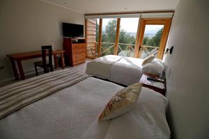Ένα ή περισσότερα κρεβάτια σε δωμάτιο στο La Reserva Lodge