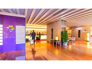 a man walking through a lobby with a purple wall at Sansuien - Vacation STAY 06801v in Kochi