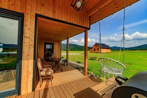 a porch of a wooden house with a swing at Domek u Anitki i Nikosia in Jeleśnia +28 photos