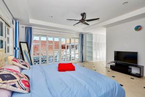 a bedroom with a blue bed and a flat screen tv at Big area!! Cozy Beach pool villa 5 private bedrooms in Pattaya South