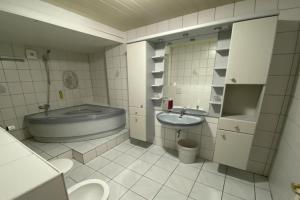 a bathroom with a sink and a tub and a toilet at Ferienhaus im Kurort inkl Frühstück in Goslar +39 photos