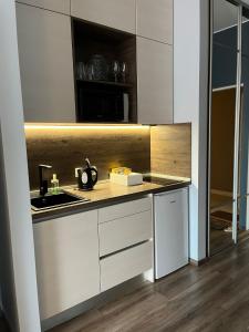 a kitchen with white cabinets and a sink at Cozy Apartment in Old Riga & Free Underground Parking in Rīga