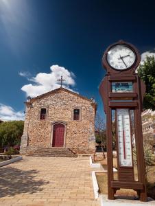 un orologio davanti a un edificio con una chiesa di Área 51 Hospedaria - STL a São Thomé das Letras