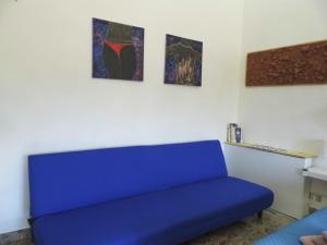 a blue couch in a room with three paintings at Suite 7 turist apartment in Paglieta