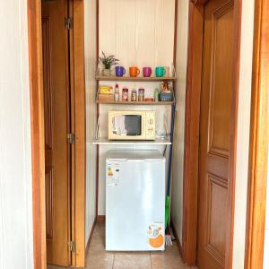 a small kitchen with a microwave and a refrigerator at Casa Roja in El Calafate