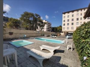 a swimming pool with two chairs and avisorvisor at Apto 539 Teresópolis in Teresópolis