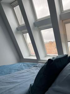 a bedroom with four windows and a bed at Cozy Apartment in Old Riga & Free Underground Parking in Rīga