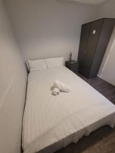 a white bed with a towel on top of it at egHoliday in London