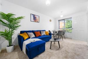 a living room with a blue couch and a table at Superb Two Bedroom House Near Etihad & Coop Live - Free Parking in Manchester