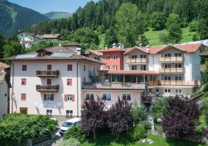 un groupe de bâtiments dans une ville de montagne dans l'établissement Alpen Garten Hotel Margherita, à Rumo