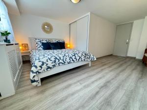a bedroom with a large bed with blue pillows at Maison confortable Chelles, entre Disney et Paris in Chelles