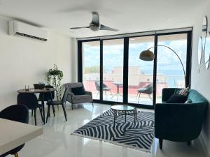 a living room with a table and chairs and a large window at New apartment Neen in Cancún