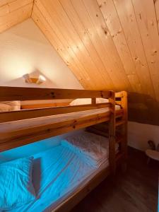 zwei Etagenbetten in einem Zimmer mit Decke in der Unterkunft Maison montagne Lélou - 4 à 6 personnes - Saint Jacques des blats in Saint-Jacques-des-Blats