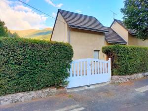 ein weißer Zaun vor einem Haus in der Unterkunft Maison montagne Lélou - 4 à 6 personnes - Saint Jacques des blats in Saint-Jacques-des-Blats