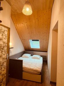 ein kleines Bett in einem kleinen Raum mit einer Decke in der Unterkunft Maison montagne Lélou - 4 à 6 personnes - Saint Jacques des blats in Saint-Jacques-des-Blats