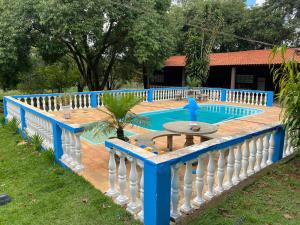 a blue swimming pool with a white fence around it at Chácara linda e espaçosa in São Carlos