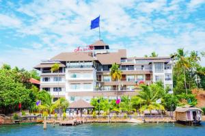 a hotel on the water with a blue flag on top at Hotel All Season in Kollam