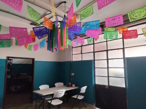 a room with a table and chairs and flags at Lidia Anturios Hostal in Oaxaca City