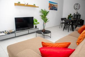 a living room with a couch and a tv at Modern Hennessy Apartment in St. Julianʼs