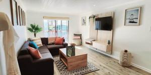 a living room with a couch and a tv at Sandy Retreat in Mossel Bay