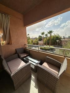 balcón con muebles de mimbre y ventana grande en Sublime Studio Prestigia Agate, en Marrakech