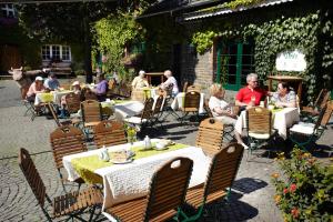 un grupo de personas sentadas en mesas en un restaurante al aire libre en Schultenhof, en Balve