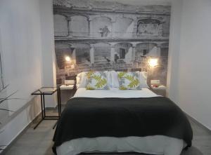a bedroom with a black and white bed and a wall at Suites Rondeña in Ronda
