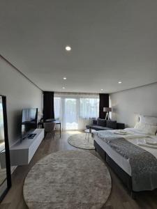 a bedroom with two beds and a television and a couch at White Estate IZM in Garbsen
