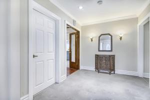an empty hallway with a white door and a mirror at 5 Bedroom Vacation Cottage - King City in Schomberg