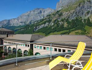 una sedia gialla seduta sul tetto di un edificio di Thermal Hotels & Walliser Alpentherme Leukerbad a Leukerbad Altre 37 foto