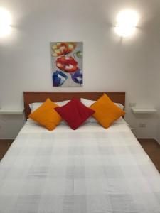 a bedroom with a bed with colorful pillows at Casa di Cristina in Fiumicino