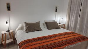 Un dormitorio con una cama grande con dos lámparas encima. en Apart Centro Paraná Apartamento entero 90m2, cochera privada para auto, excelente ubicación, a mts del Shopping Paso del Paraná, zona Parque y Peatonal, en Paraná